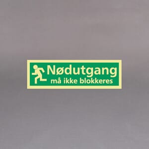 Plastskilt etterlysende utg. skilt Nødutgang må ikke blokkeres 33x10cm